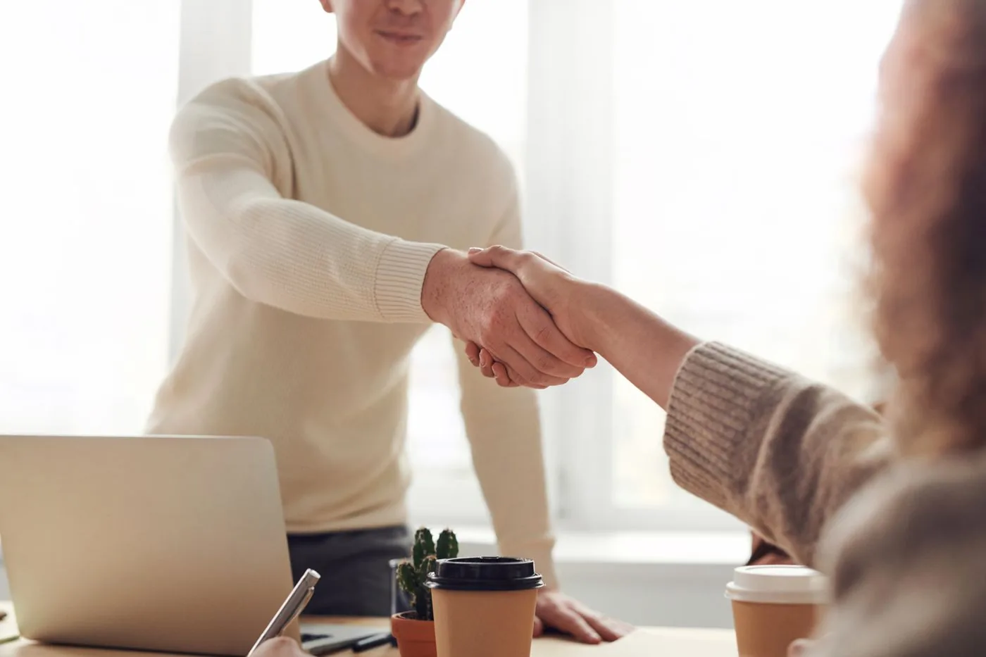 Photos that improve business profiles — two professionals shaking hands across a desk