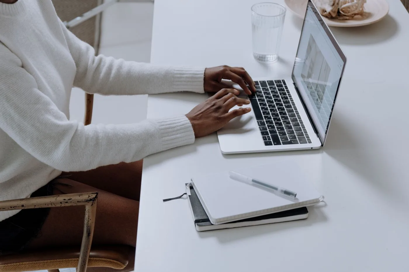 Storytelling in marketing — hands typing content on a laptop beside a notebook